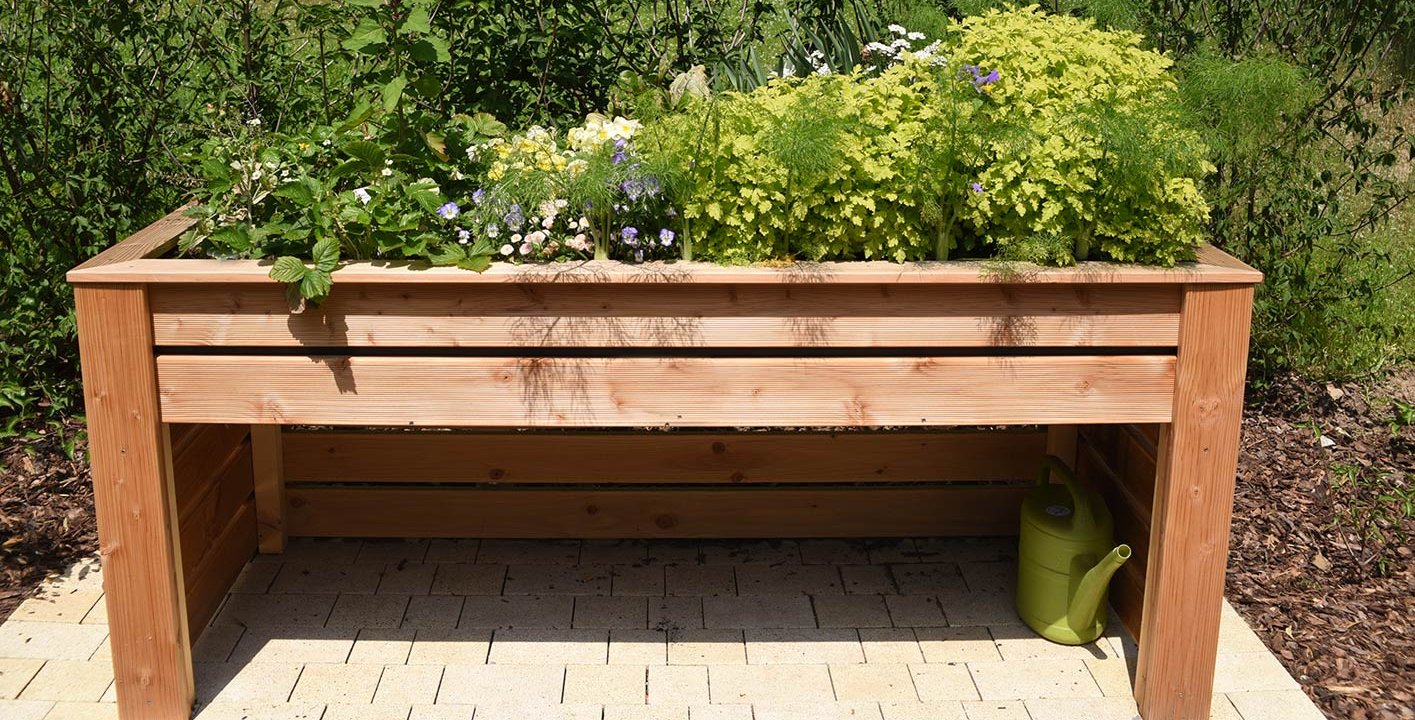 Ein bepflanztes Hochbeet im grünen Garten