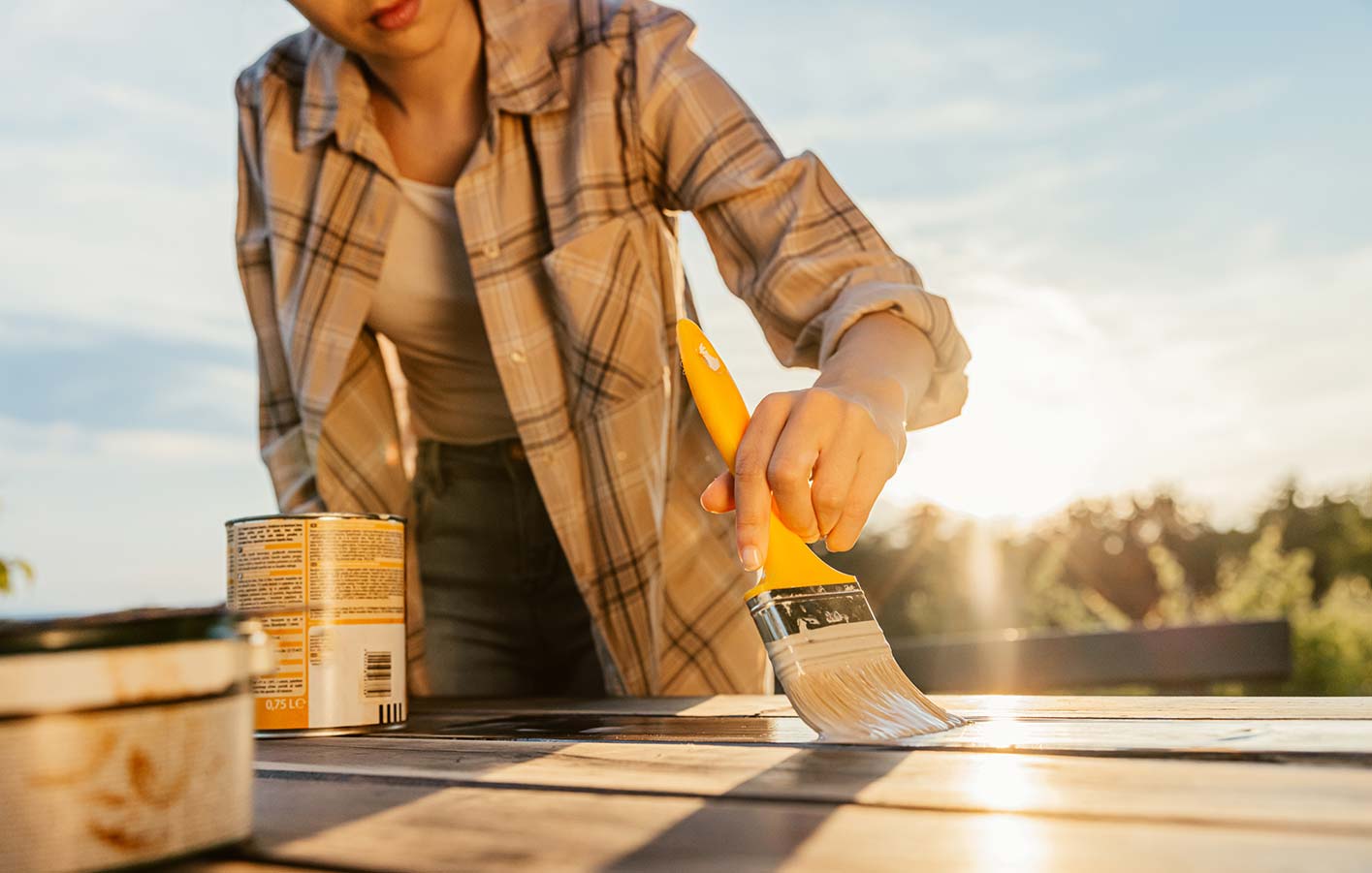 Frau streicht Gartentisch